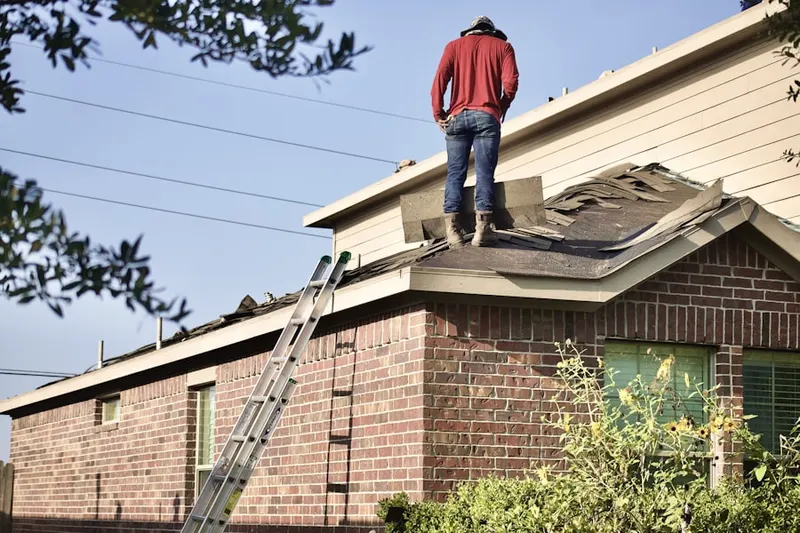 Professional roofer working on a residential roof in Old Field